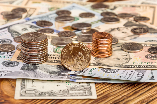 Stack of  american coins on the dollar banknotes